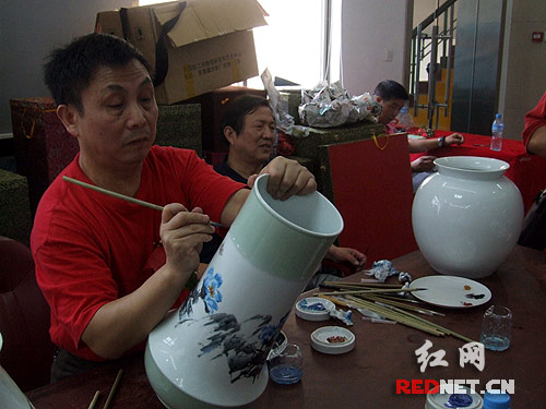 著名花鳥畫家王國勛在現(xiàn)場繪制陶瓷藝術(shù)品。