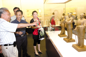 今年7月20日,石灣陶藝回顧展在省博物館開展,參觀者在參觀由中國工藝美術(shù)大師劉澤棉(左)等6位國家級陶藝大師共同創(chuàng)作的《東方偉人》作品。(資料圖片)/ 佛山日報記者甘建華攝
